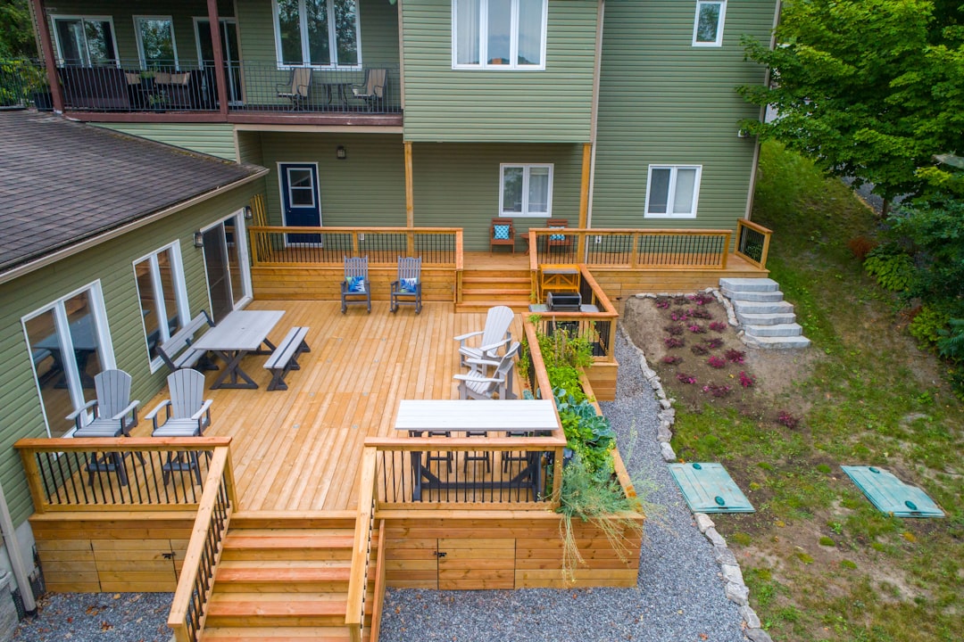 a deck with chairs and tables on it next to a house a deck with chairs and tables on it next to a house