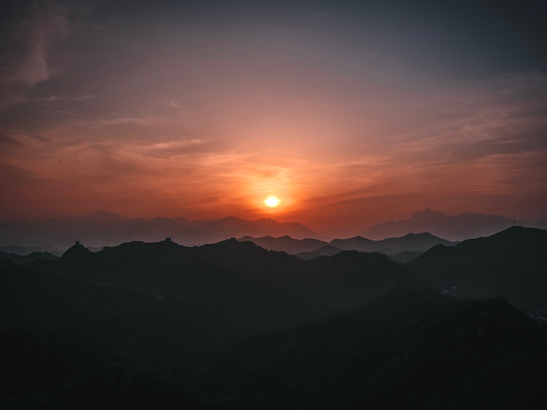 the sun is setting over a mountain range