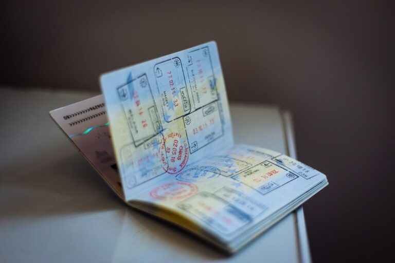 An open passport with numerous ink stamps on the pages on a table